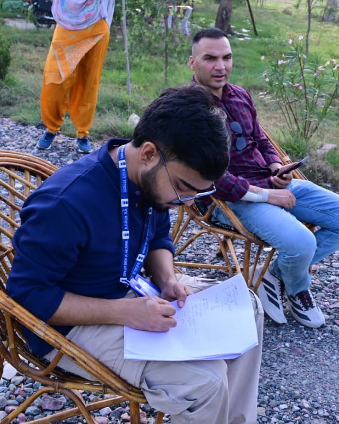 Arkraj Biswas writing survey notes outdoors during fieldwork