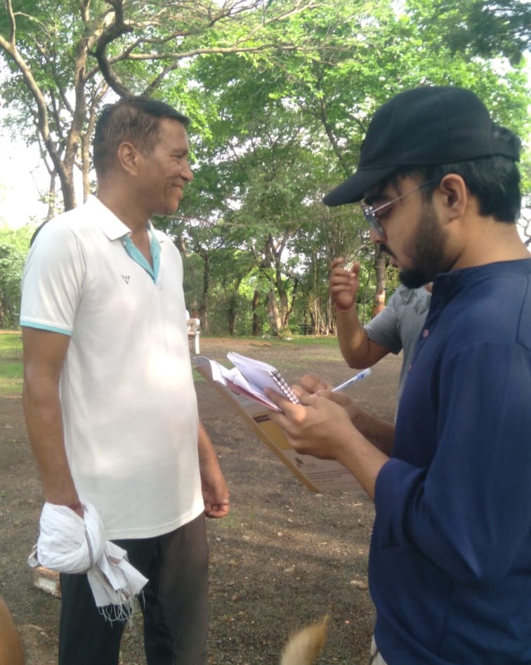 Arkraj Biswas interviewing a visitor with a notebook during fieldwork
