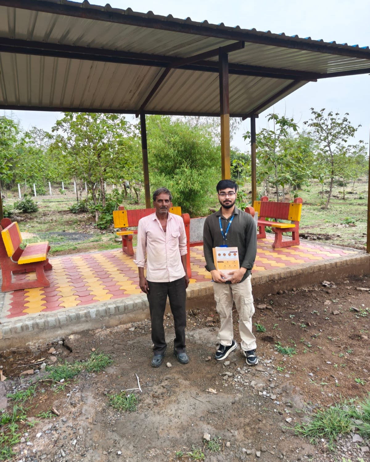 Arkraj Biswas with a field worker at a park shelter, holding survey sheets